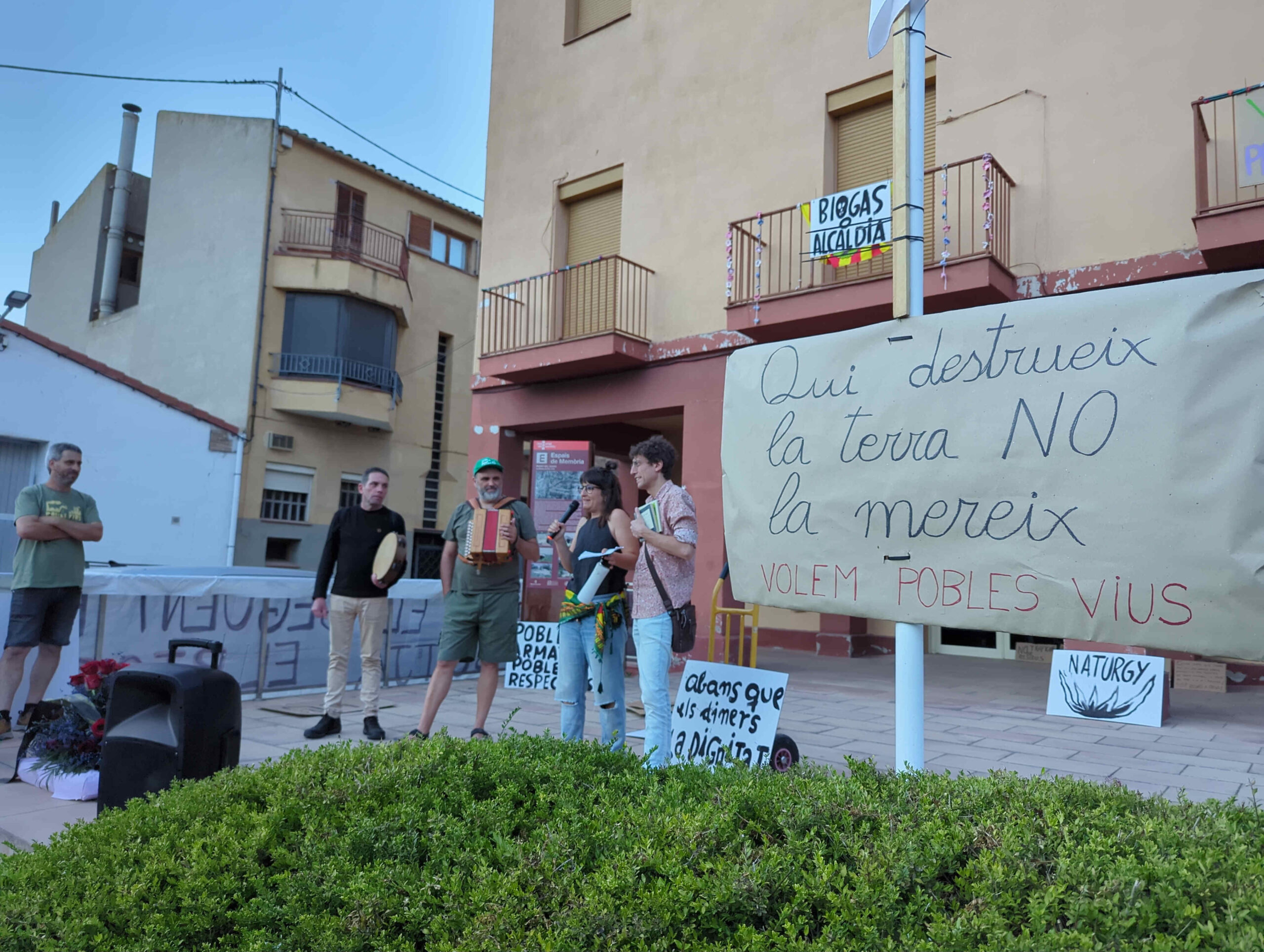 Cartell "Qui destrueix la terra NO la mereix" a l'inici de la romeria popular a l'ajuntament de La Sentiu.