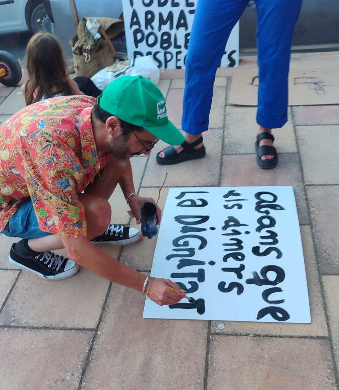 Gent fent pancartes davant l'ajuntament de La Sentiu. "Abans que els diners la dignitat"