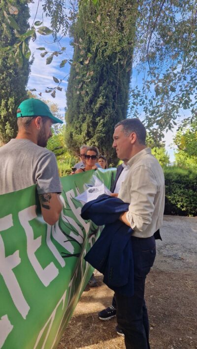 Manifestants de Pobles Vius durant la visita del Govern a les Avellanes, a finals d'Agost de 2026. Un manifestant li fa saber les inquietuds a Òscar Ordeig.
