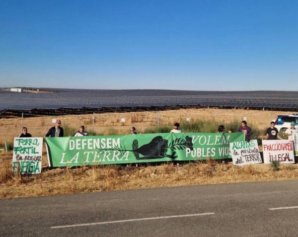Manifestants de Pobles Vius durant la visita de Salvador Illa a Alcarràs per inagurar la macrocentral més gran de Catalunya, a data d'Agost de 2026, amb 500 hectàrees de moment.