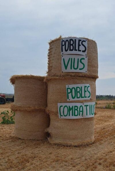 Paques de palla amb cartell enganxat: "Pobles vius, pobles combatius"